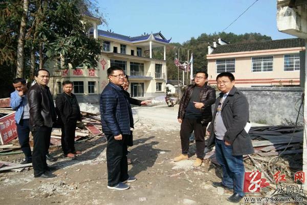 图为永顺县委常委,县委办主任张艳阳(中)一行察看塔卧镇仓坪村新建村